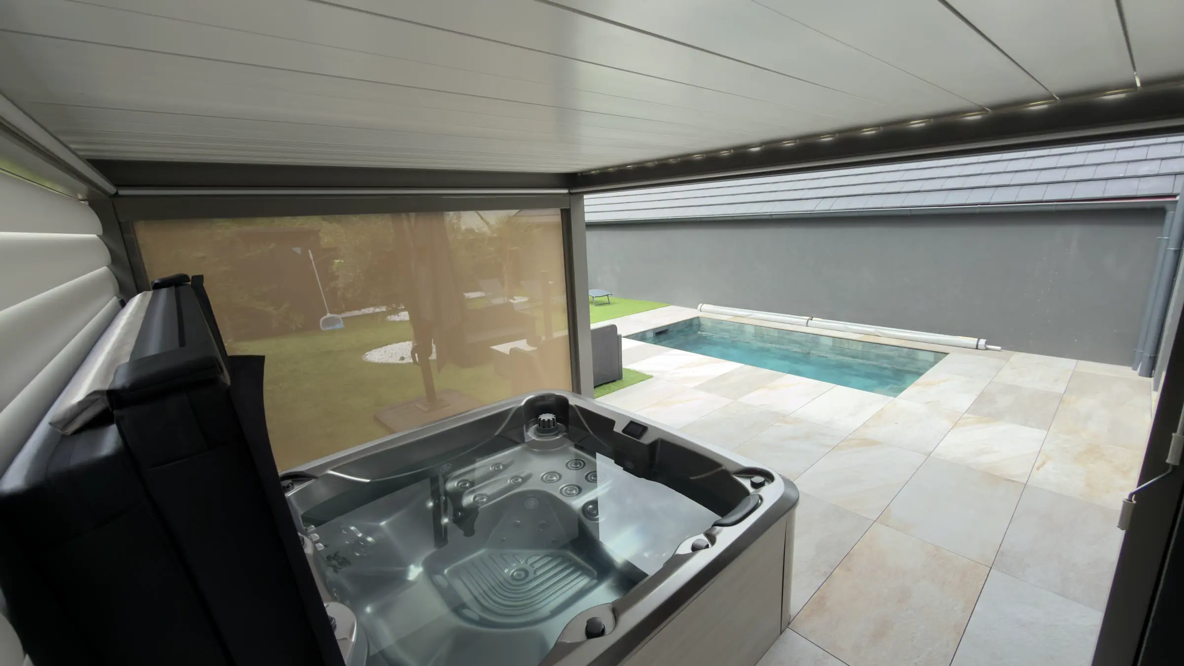 Le jacuzzi sous abri, face à la piscine