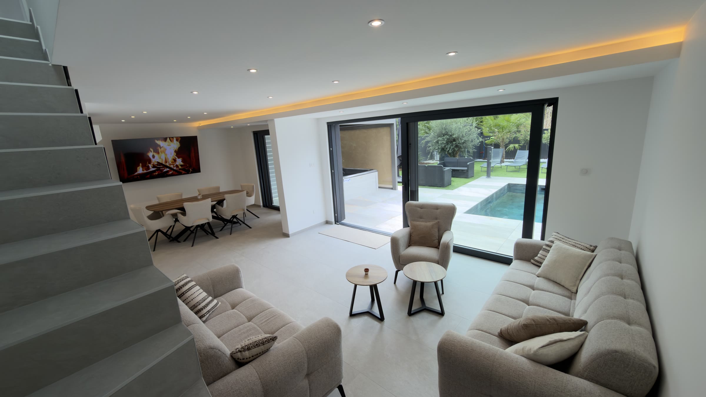 Le salon vu depuis l'escalier, ouvert sur la salle à manger et la terrasse